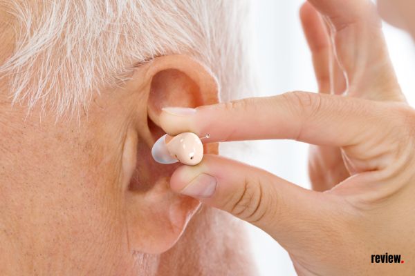 Elder Using Audien Atom Pro 2 Hearing Aid In The Ear